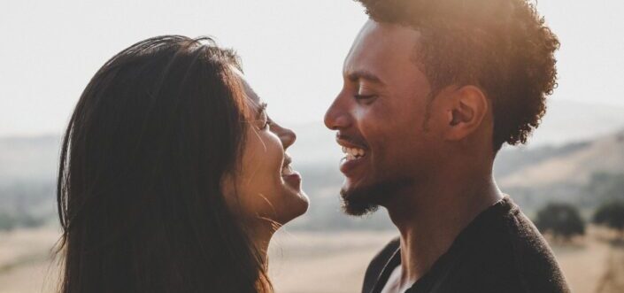 Couple laughing together outdoors.