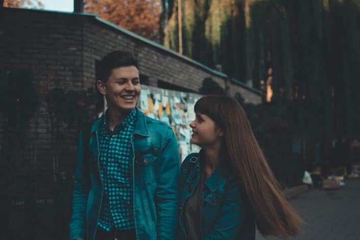Couple smiling at each other while walking.