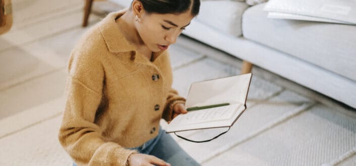 woman reading notes in notebook