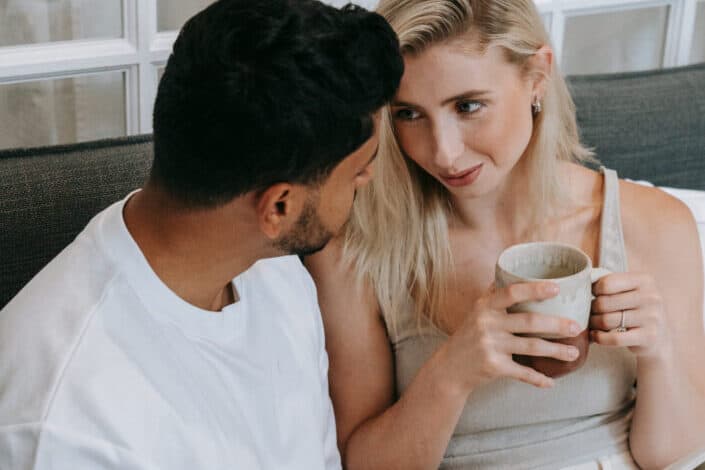 Woman smiling at his partner while holding coffee