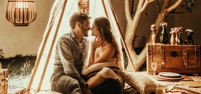 Couple dating on a teepee at night.