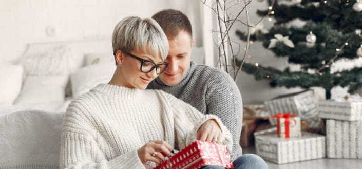 Woman opening Christmas present from her boyfriend
