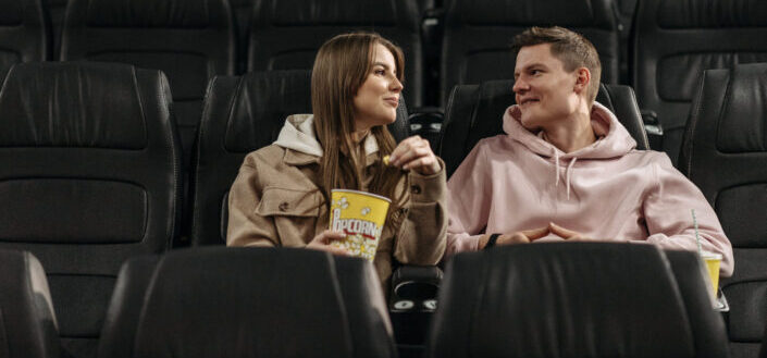 couple eating popcorn in the movie theater