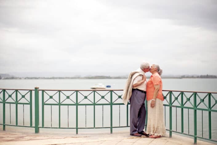 Stylish Elderly Couple Kissing on Embankment