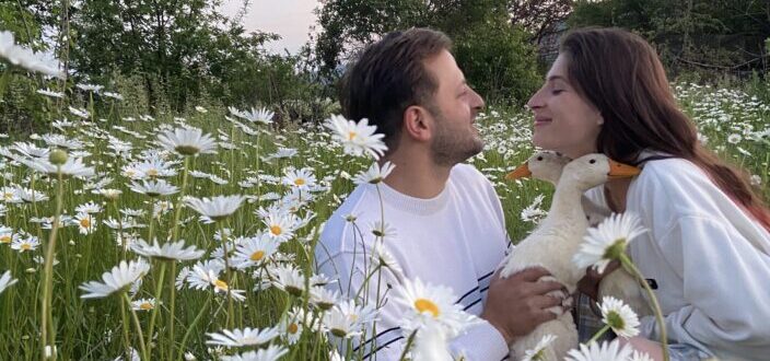 Couple in The Flower Field Holding Geese