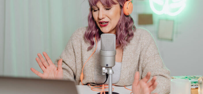 A woman talking on a microphone while wearing a headphone