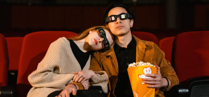 Couple with 3d glasses and popcorn in yellow tumbler