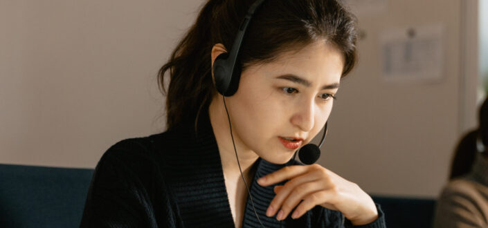 woman-with-black-headset-and-mouthpiece-sitting-in-front-of-laptop-stockpack-pexels