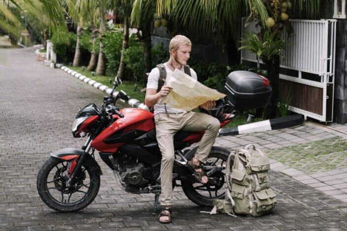 Man Looking at Map Sitting on Motorbike