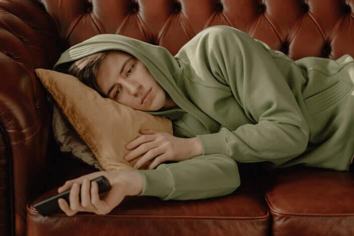 Man in Green Hoodie Lying on Couch