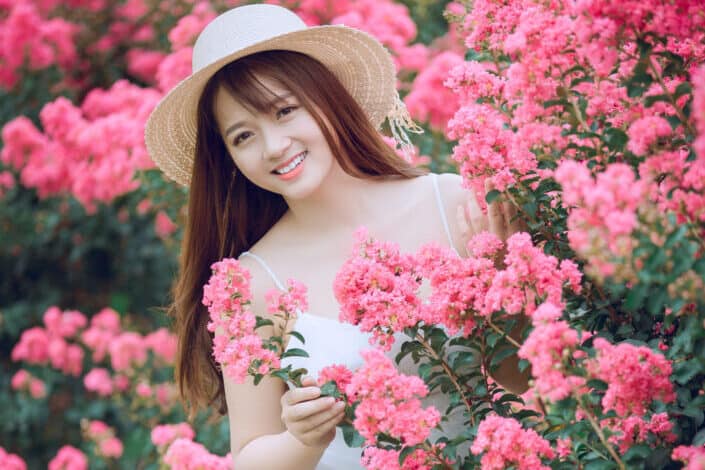 Woman in a flower garden smiling on the camera
