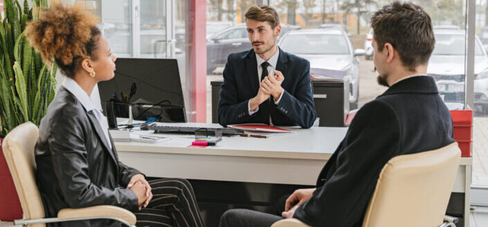 man in a suit talking to the employees