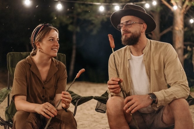 Cute Questions to Ask Your Boyfriend - Couple eating by the bonfire