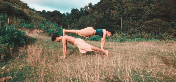 Man and woman doing yoga in a forest