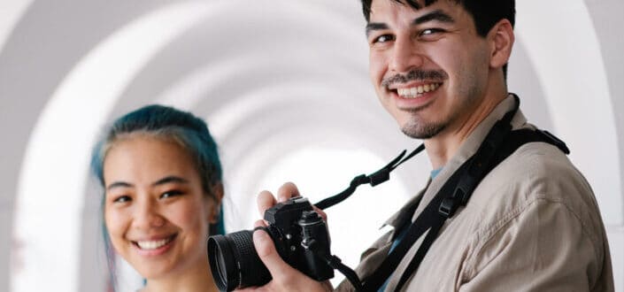 Man holding camera and woman smiling at the camera