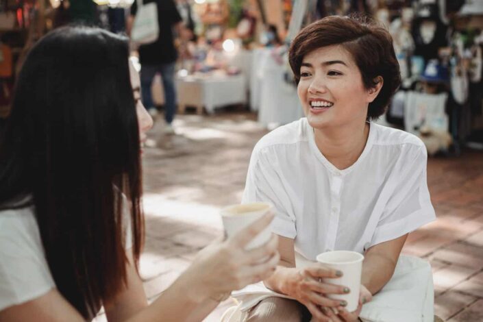 Cheerful Women Enjoying Coffee in Outdoors Cafe