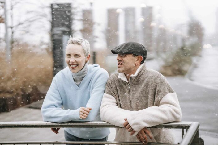 Content couple speaking on urban embankment in autumn