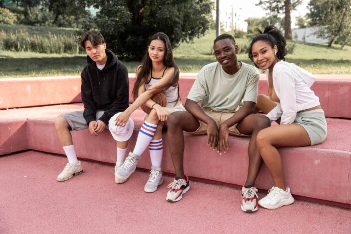 Group of Friends Resting on a Stone Bench in Park