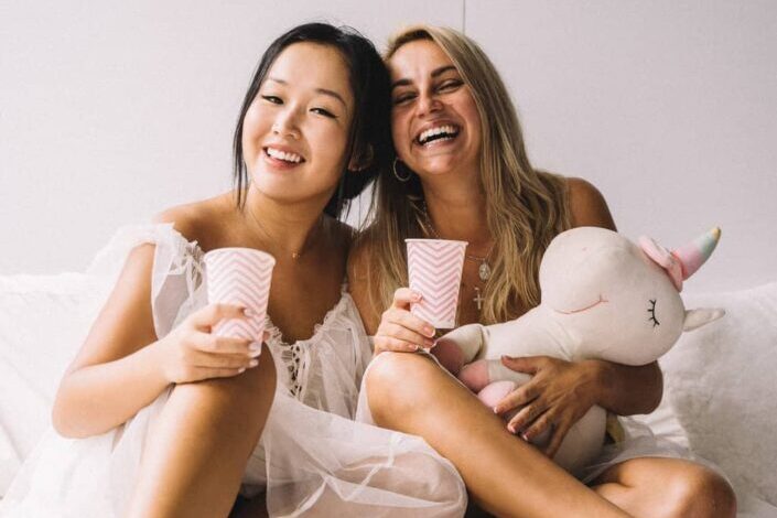 Two Girls Smiling While Holding Cups