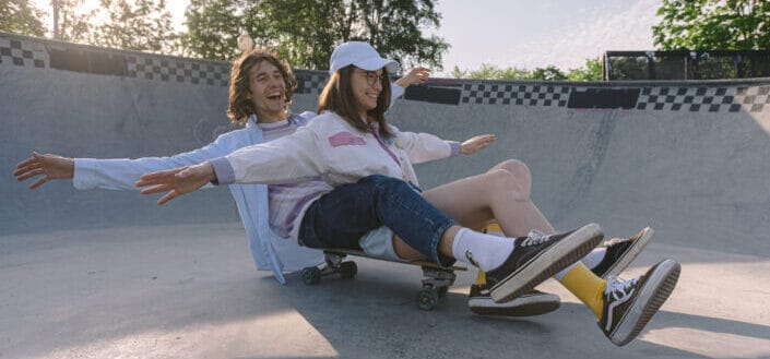 Couple Sitting on a Skateboard