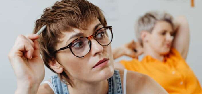A woman wearing eyeglasses while thinking