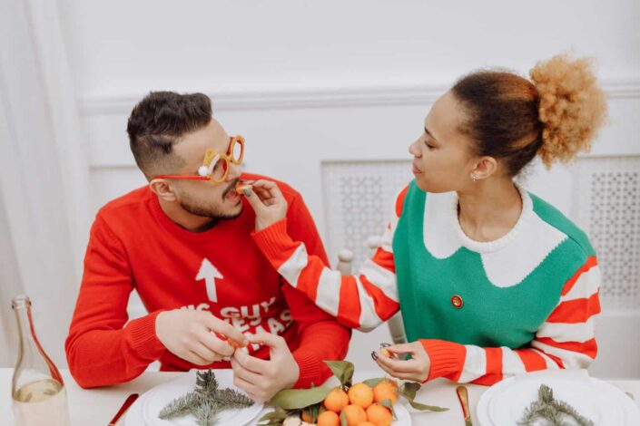 A woman feeding a man an orange