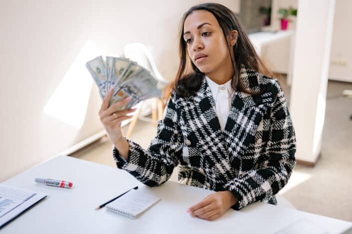 A woman in plaid coat holding money