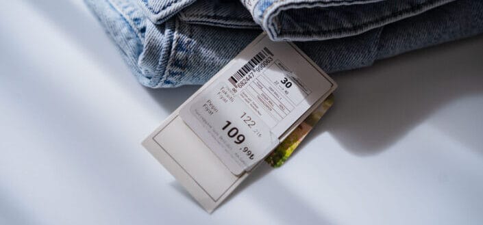 Jeans With Price Tag on White Table