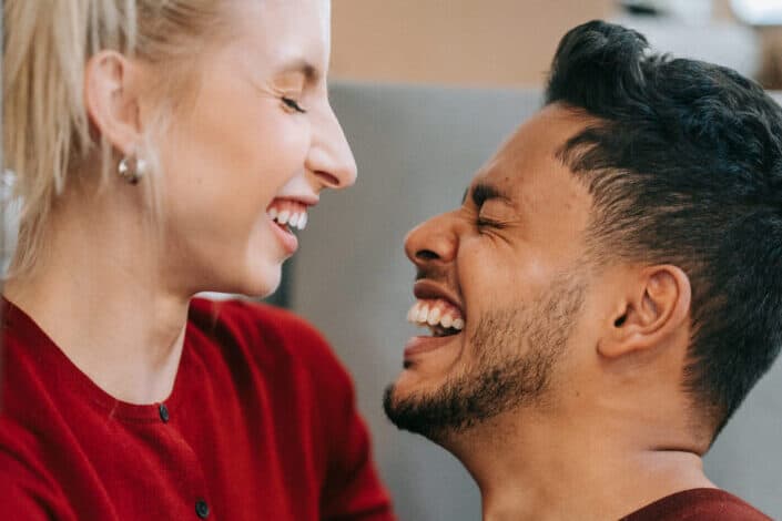 Man and Woman in Red Long Sleeves Laughing Together