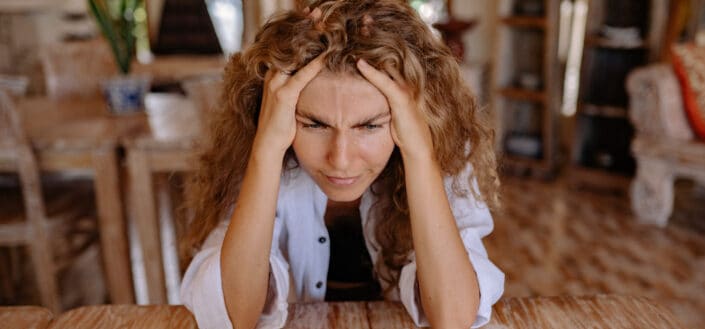 woman leaning on wooden table while looking upset