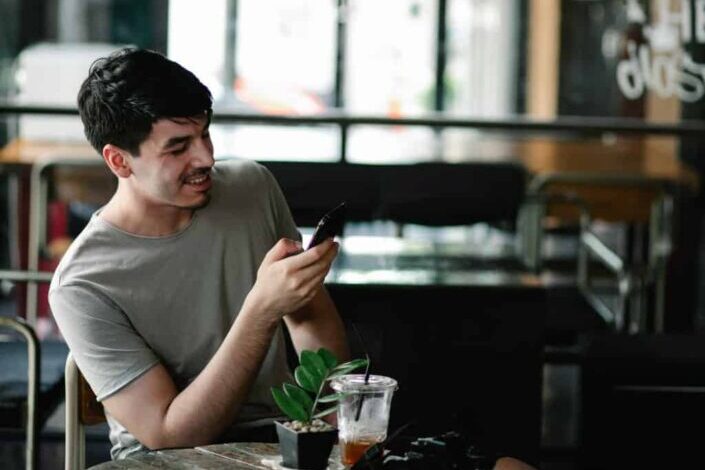 young man browsing his smartphone in cafe