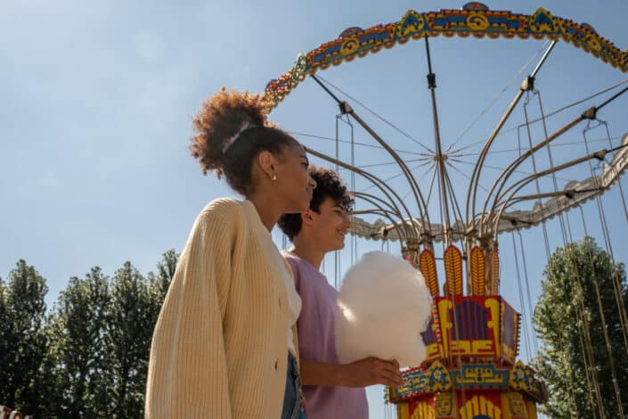 Teenage couple walking by big carousel