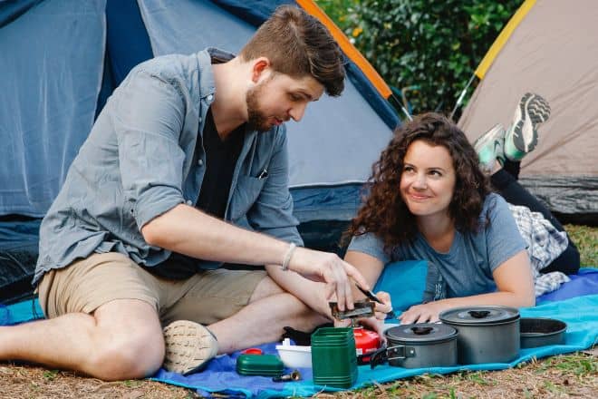 Truth or dare questions for boyfriend - Happy young couple preparing lunch during camping in forest