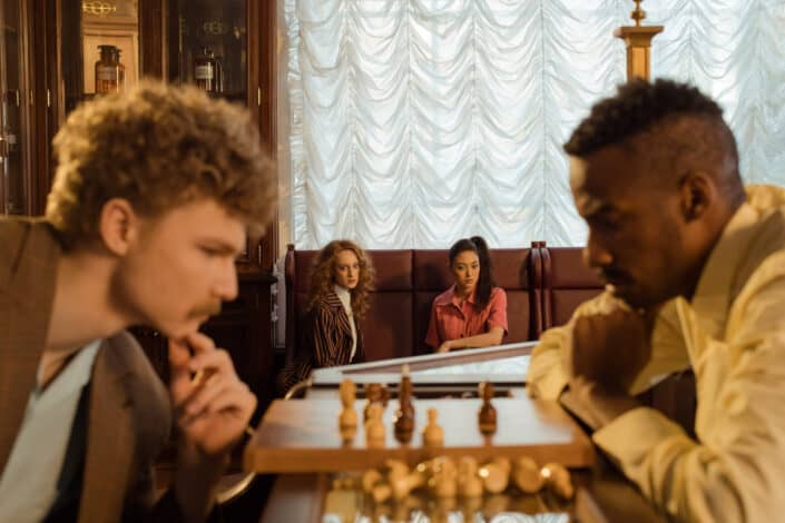 Women Watching Men Playing Chess
