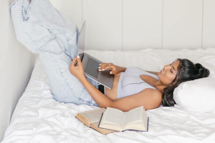 A woman using a laptop in bed
