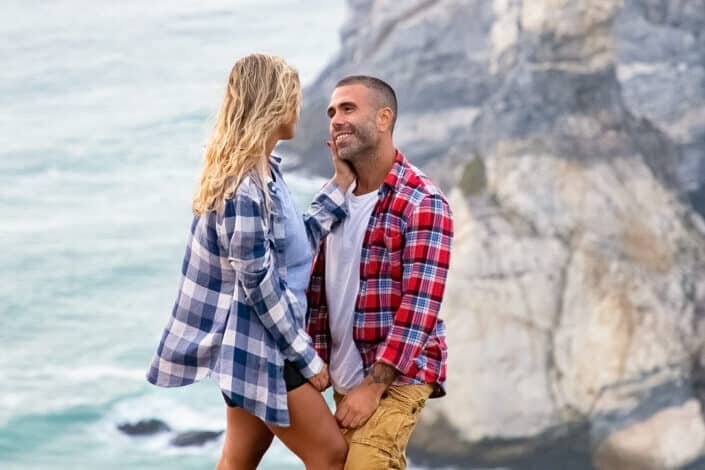 Couple standing on a cliff and smiling