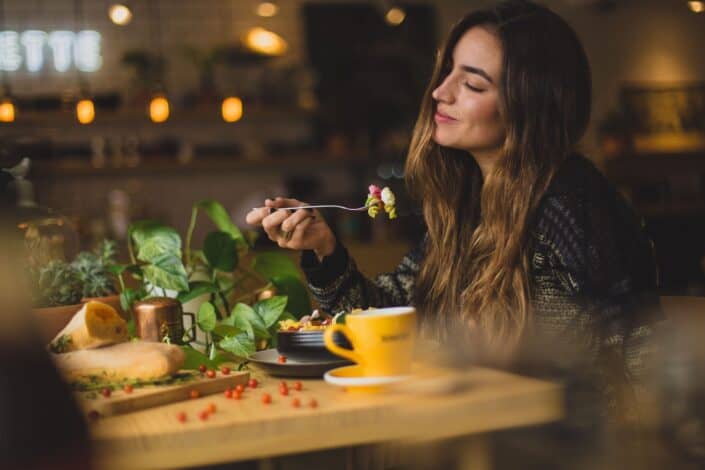 woman eating happily in a cafe