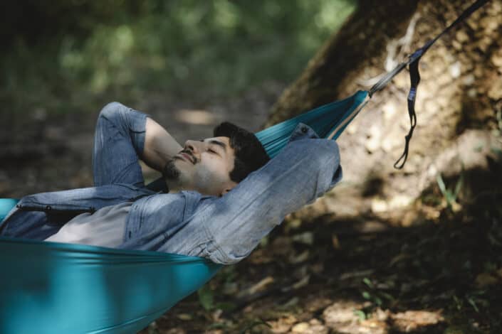 Man resting in hammock in woods
