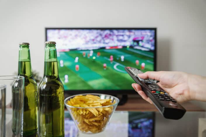 Person watching sports through flat screen television