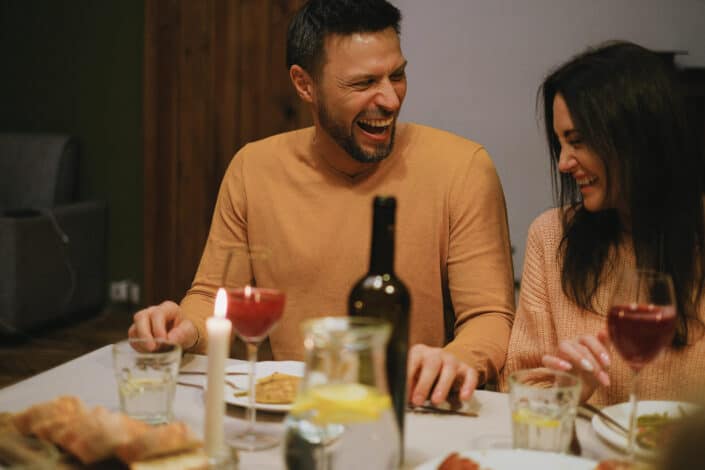 Man and woman laughing over dinner