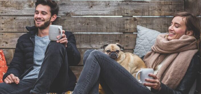 man and woman relaxing with dog