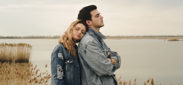 woman in jacket leaning on man's shoulder