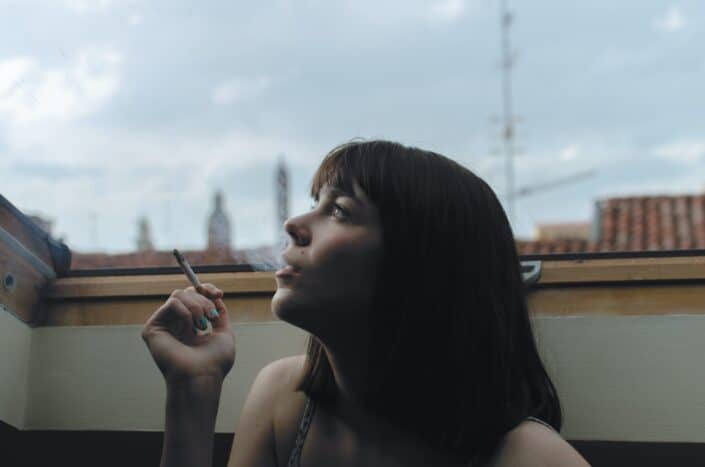 Woman holding a stick of cigarette during day time