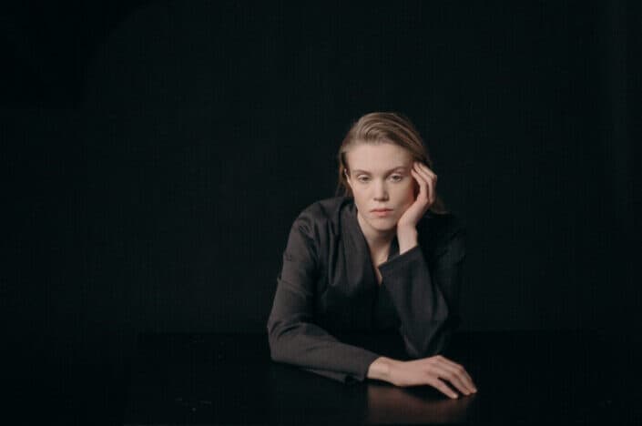 Woman in black coat sitting