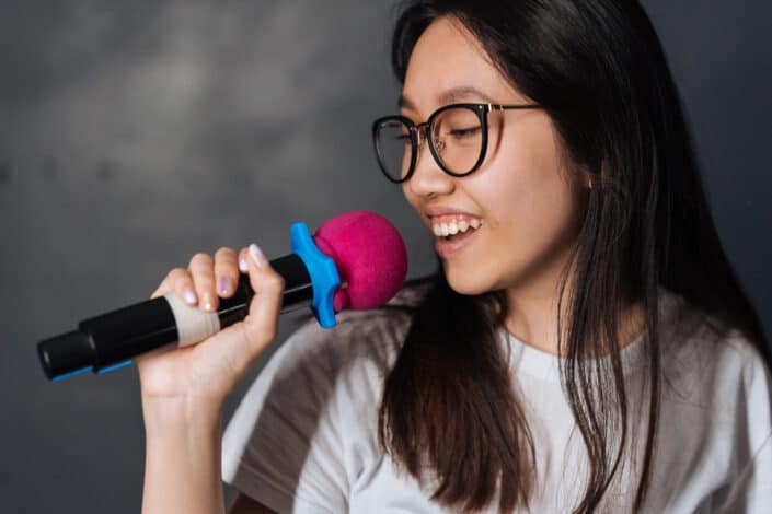 Young woman with eyeglasses using a microphone