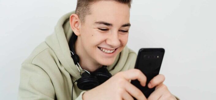 Teenager Holding a Smartphone Smiling