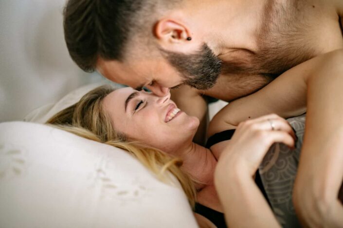 Couple lying on bed smiling