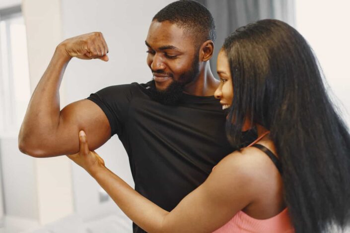 Man presenting his arm muscle to a woman