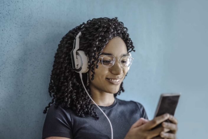 Woman Wearing White Headphones Checking Her Phone