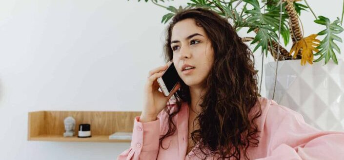 Woman With Curly Hair Talking to Someone on the Phone